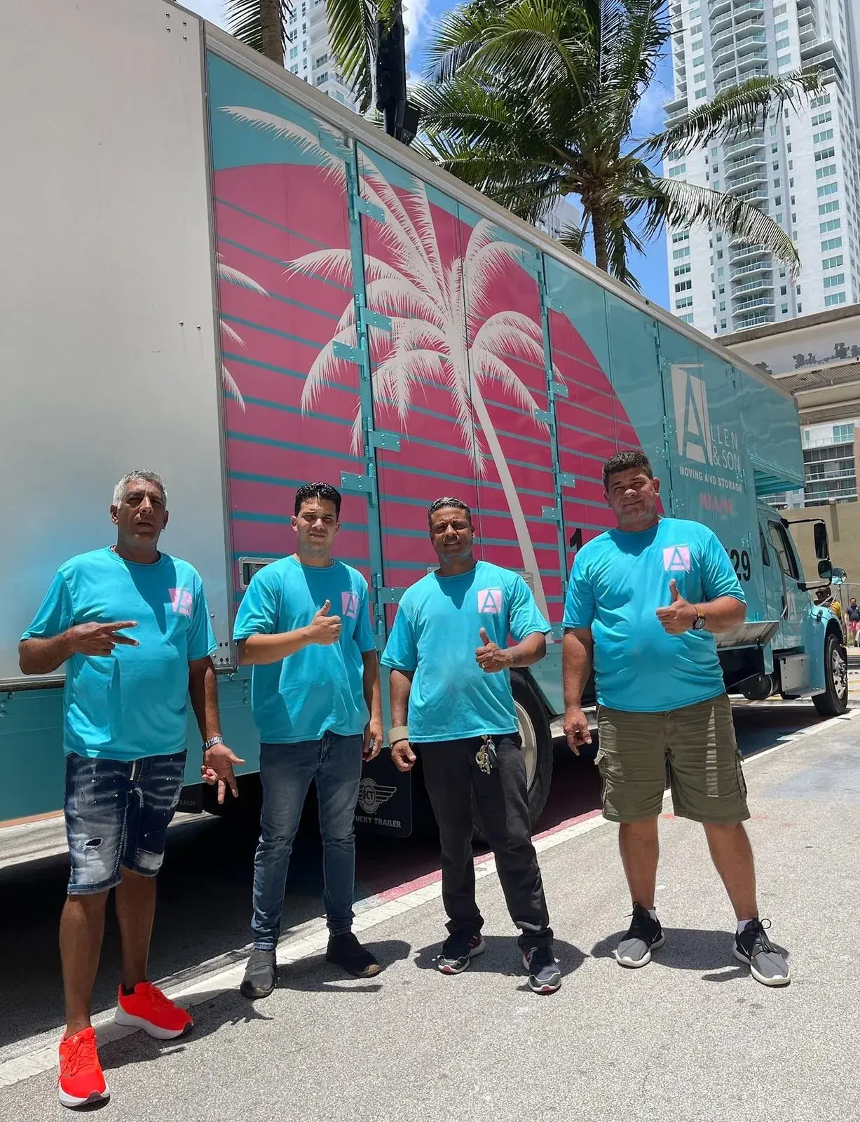 Four Allen & Son Moving crew members in company t-shirts in front of the company truck